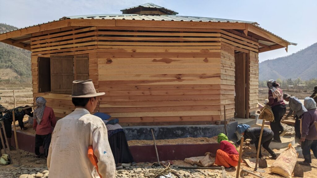 Villagers working on a school structure